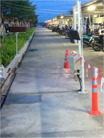 ช่องทางวิ่งเฉพาะสำหรับรถมอเตอร์ไซค์ มีเสาอากาศ RFID และตู้ควบคุมติดตั้งข้างทาง ถัดไปเป็นลานจอดรถมอเตอร์ไซค์ของพนักงาน
